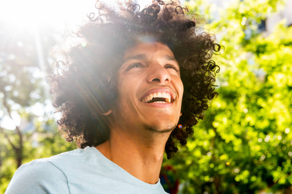 Young man outside smiling in the sun
